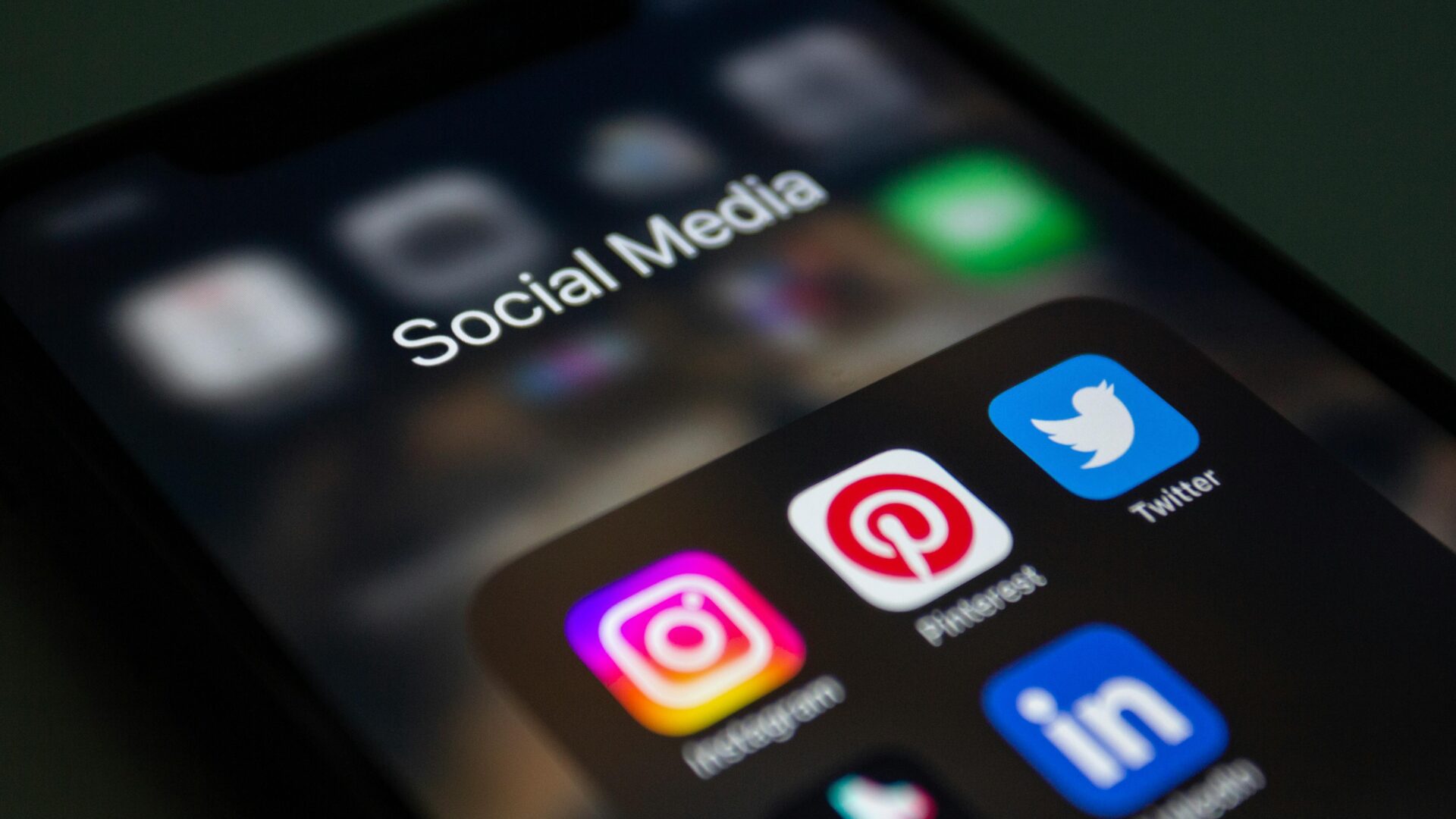 Smartphone-Display mit Social-Media-Icons wie Instagram, Twitter, LinkedIn und Pinterest.