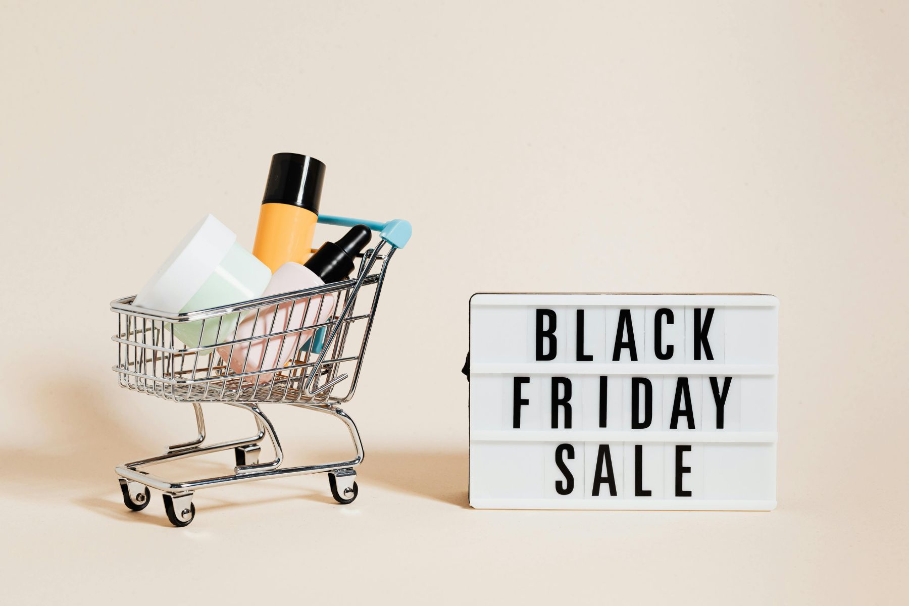 Einkaufskorb mit Produkten und "Black Friday Sale" Leuchtkasten.