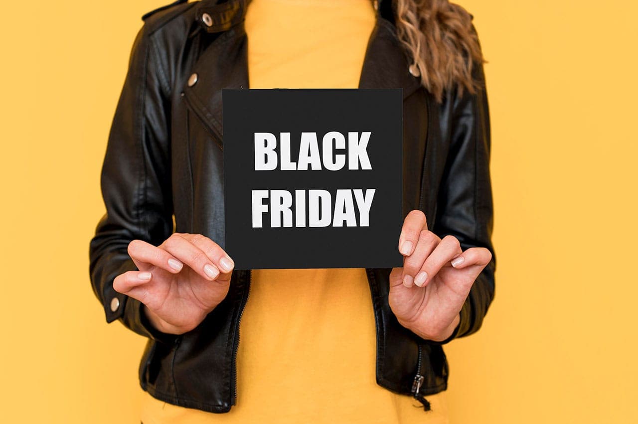 Frau hält "Black Friday" Schild vor sich, Marketing für Dienstleister an Black Friday.